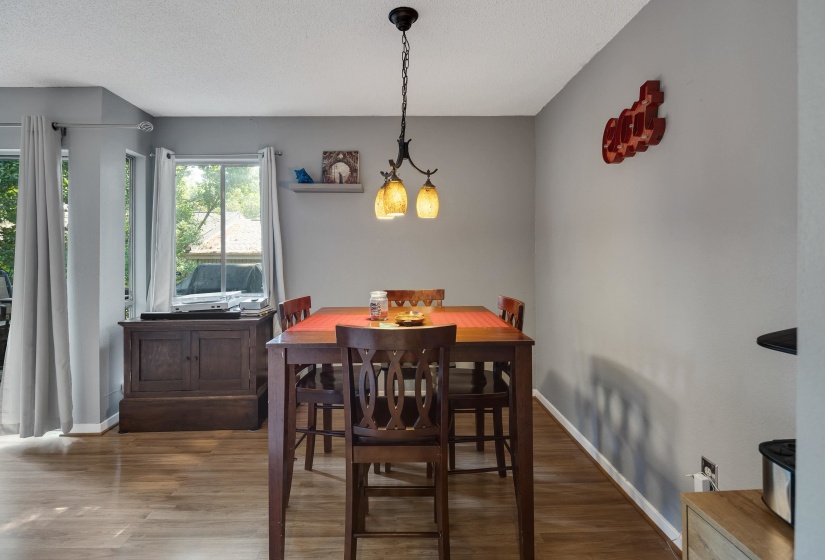Dining space with wood finished floors and a textured ceiling