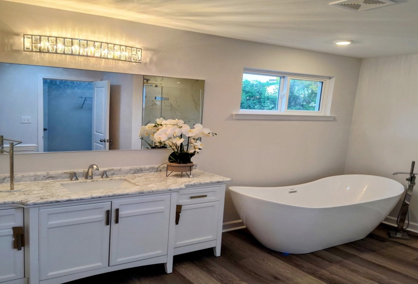 Experience the ultimate in relaxation in the luxurious master bath, which features a spacious walk-in closet and a stylish storage vanity. Enjoy the elegance of a standalone tub and a large marble shower, creating a serene retreat for your daily routine.