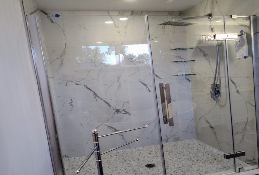 Huge marble shower with pebble floor to soothe your feetA spacious marble shower featuring a pebble floor to provide comfort for your feet.