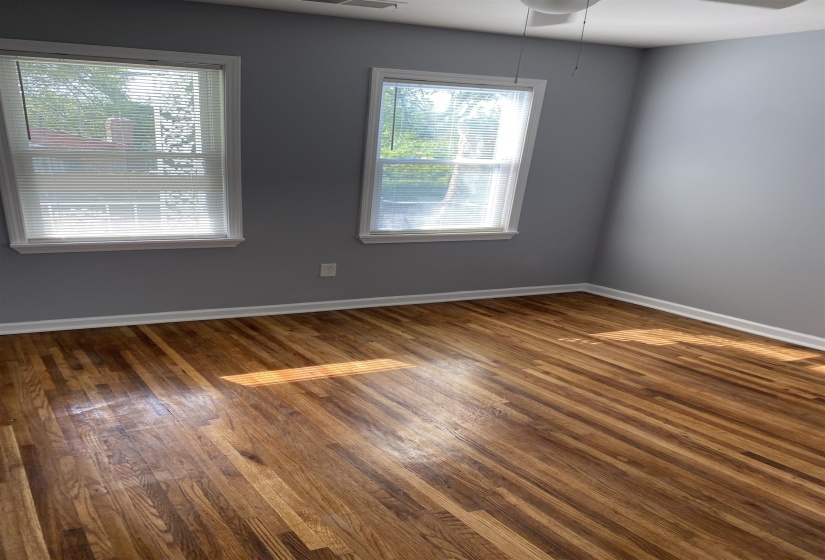 Unfurnished room with dark wood-style floors and ceiling fan