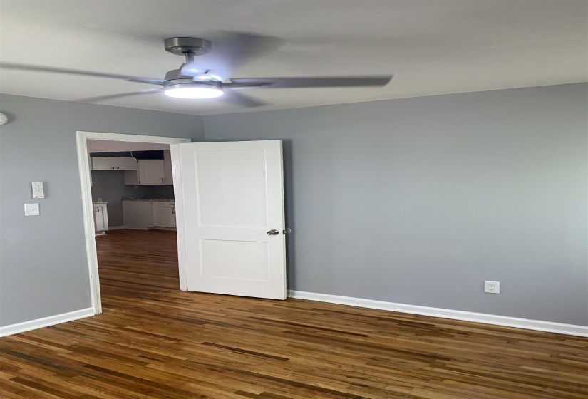 Unfurnished room with dark wood-style floors and ceiling fan