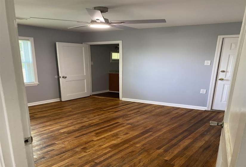 Unfurnished bedroom with dark wood-type flooring and ceiling fan