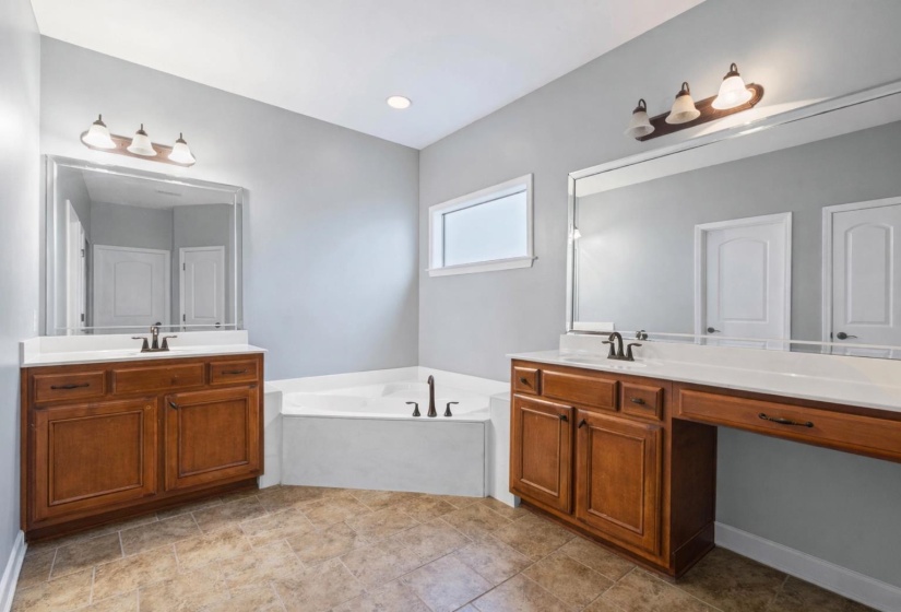 Full bath with two vanities and a garden tub