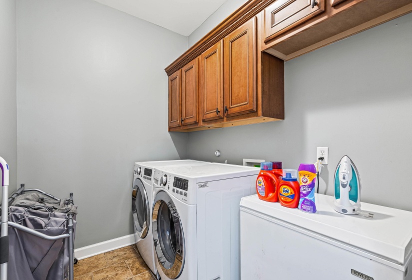 Laundry area with cabinet space, separate washer and dryer, and stone finish floors