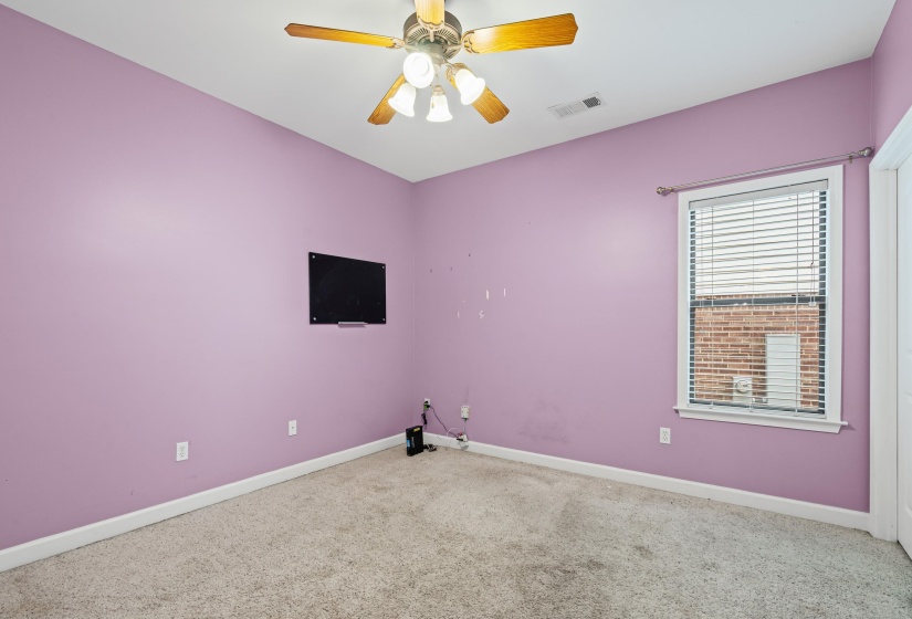 Empty room with a ceiling fan and carpet