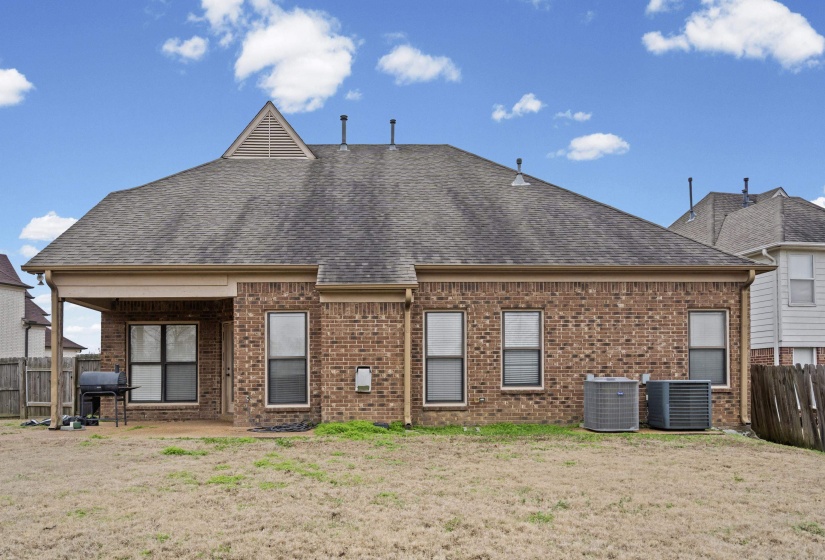 Rear view of property featuring a patio area, brick siding, and a shingled roof