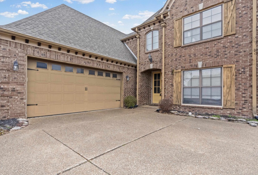 View of front of home with brick siding, driveway, a shingled roof, and an attached garage