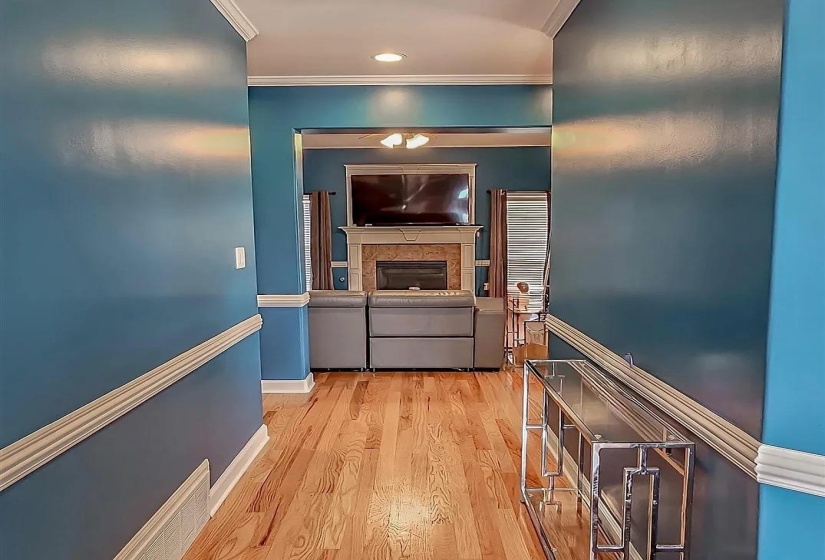 Hall featuring light wood-style flooring and ornamental molding