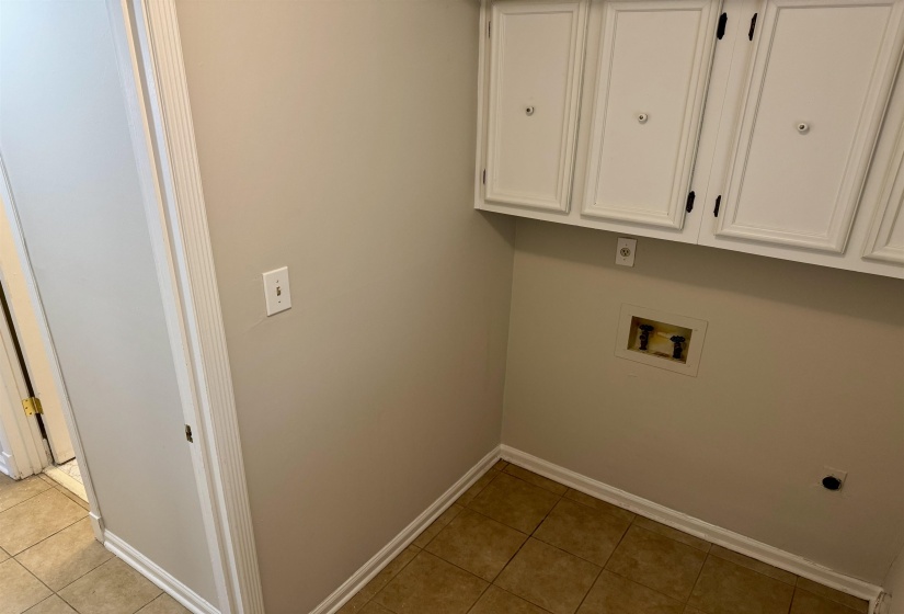 Laundry room featuring cabinet space, hookup for a washing machine, light tile patterned floors, and hookup for an electric dryer