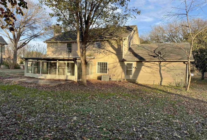 Rear view of house with a sunroom and a chimney