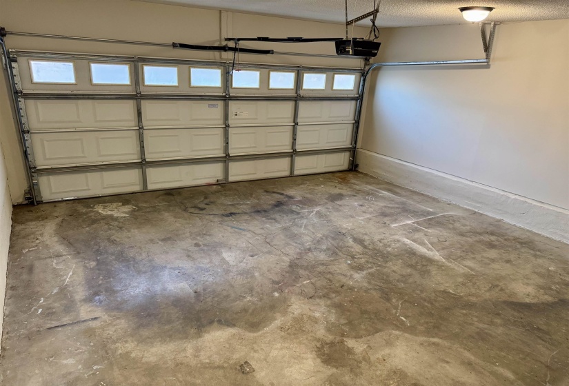 Garage with a garage door opener and baseboards