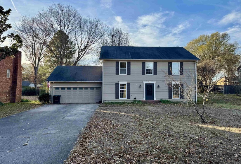 Colonial house featuring an attached garage and driveway