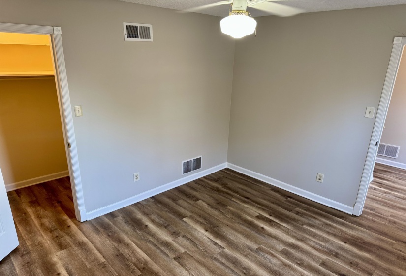 Empty room with a ceiling fan and dark wood finished floors