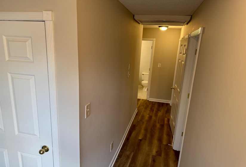 Corridor featuring dark wood-style floors and a textured ceiling