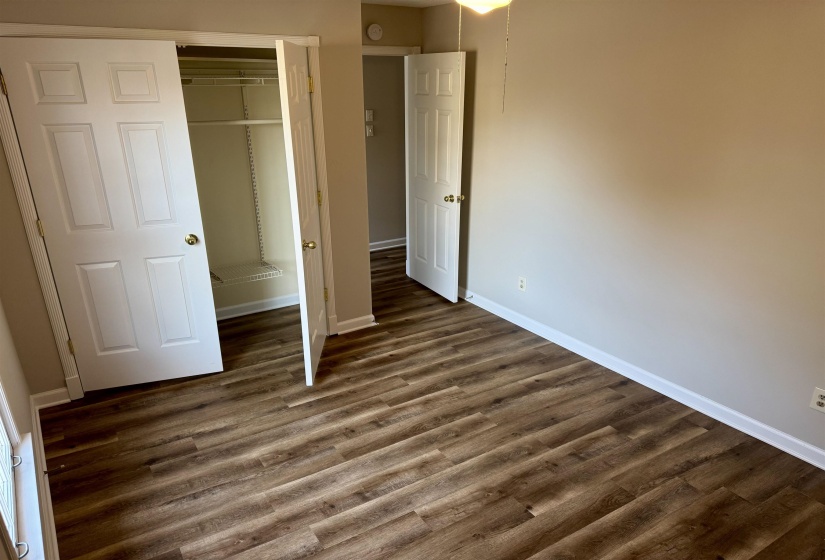Unfurnished bedroom featuring dark wood-style flooring and a closet