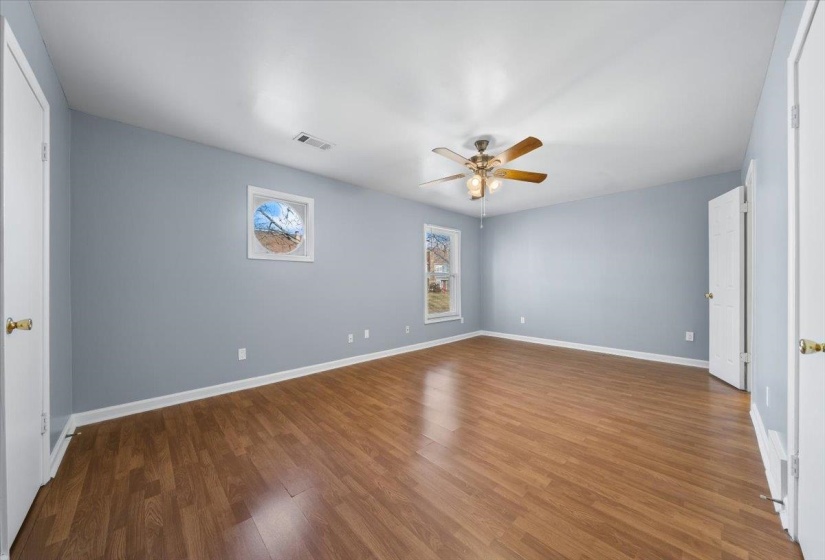 Empty room with dark wood-type flooring and ceiling fan