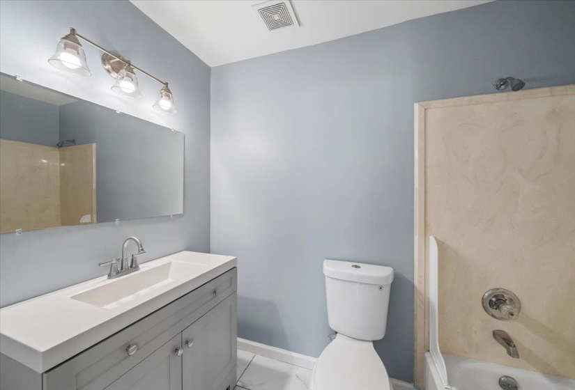 Full bath with vanity, bathtub / shower combination, and light marble finish flooring