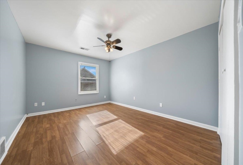 Empty room featuring wood finished floors and a ceiling fan