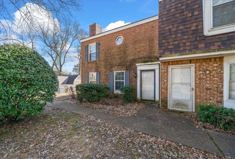 Property entrance with brick siding and a chimney