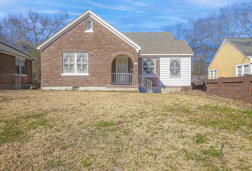 View of front facade with a front lawn and brick siding