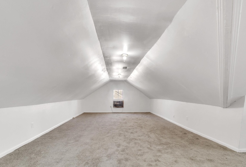 Additional living space with lofted ceiling and carpet