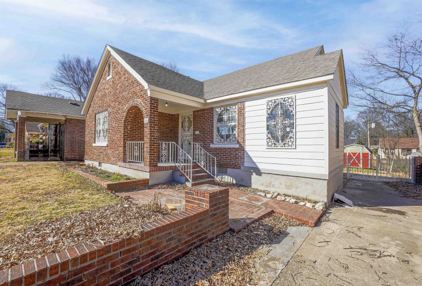 View of front of property with brick siding, a shingled roof, and a front yard