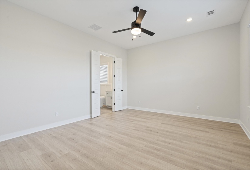 Spacious room featuring wood-finish flooring, light gray wall paint, and white baseboards