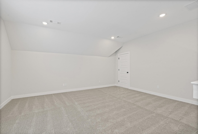 Versatile room featuring sloped ceilings, recessed lighting, and neutral-toned carpeting