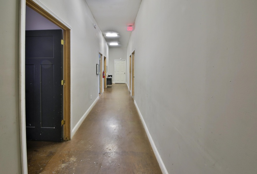Hall with baseboards and concrete floors