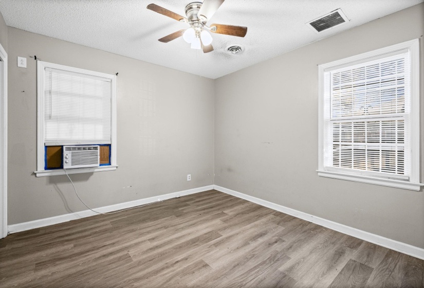Empty room featuring wood finished floors, a textured ceiling, ceiling fan, and cooling unit