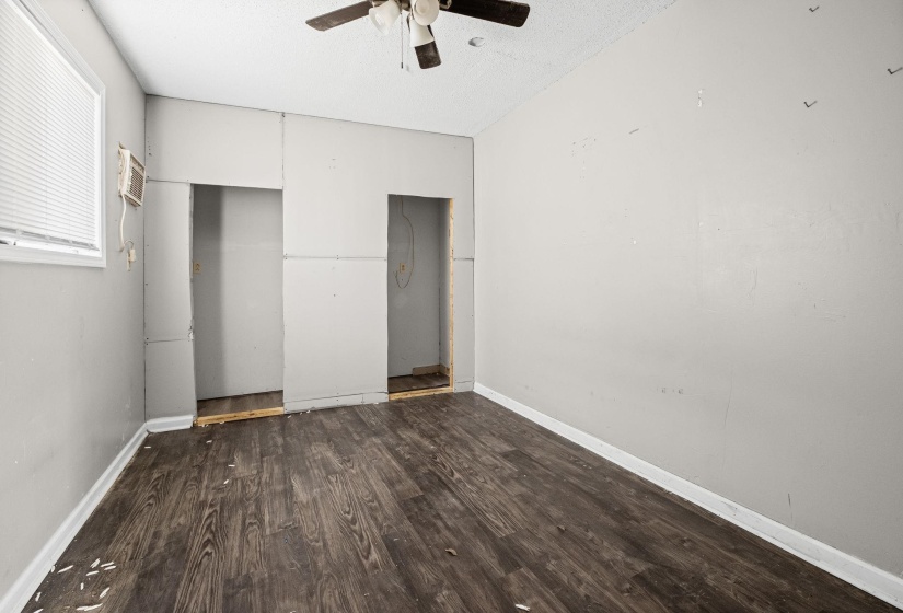 Unfurnished bedroom with dark wood-style flooring, a ceiling fan, and a textured ceiling