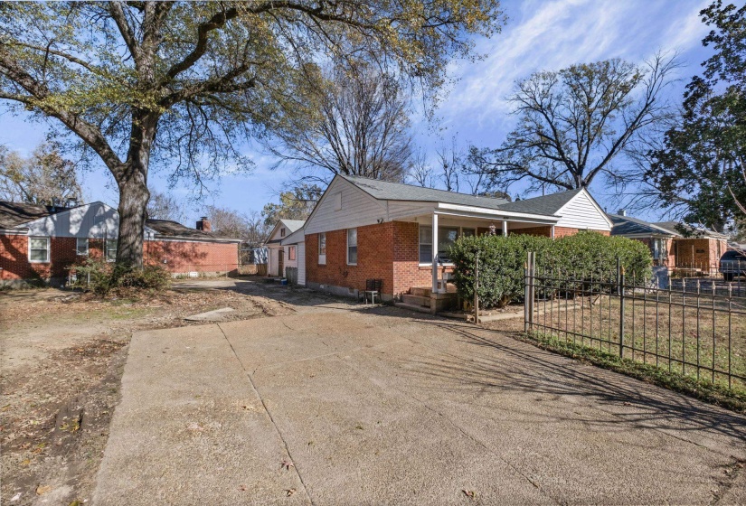 View of side of home with brick siding and concrete driveway