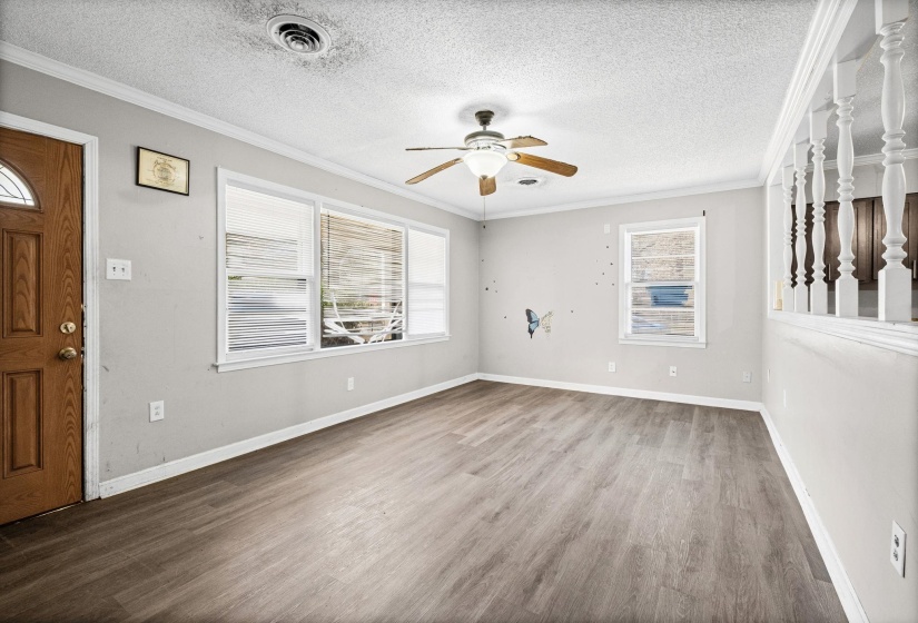 Entrance foyer featuring crown molding, wood finished floors, healthy amount of natural light, a textured ceiling, and a ceiling fan