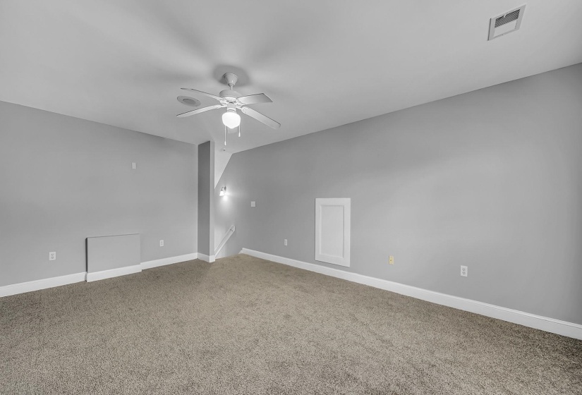 Spacious room featuring neutral carpeting and light gray walls