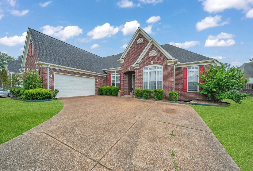 Brick exterior residence with a concrete driveway, attached garage, and gabled roofline