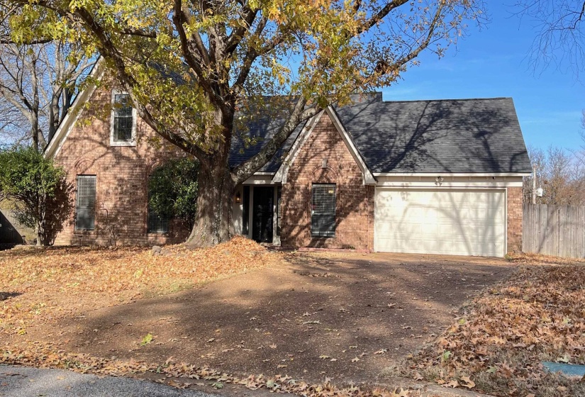 View of front of home featuring brick siding, a garage, and driveway