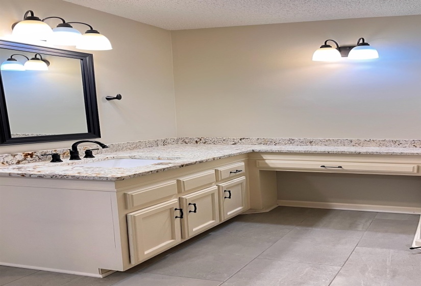 Bathroom with vanity, a textured ceiling, and light tile patterned floors