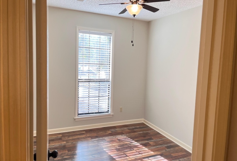 Empty room with dark wood-style floors, a textured ceiling, and a ceiling fan