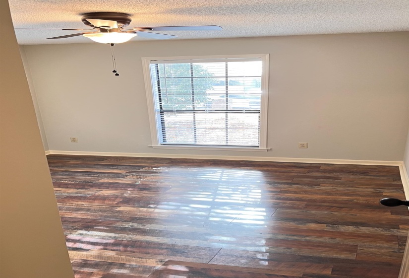 Spare room with dark wood-type flooring, a textured ceiling, and ceiling fan