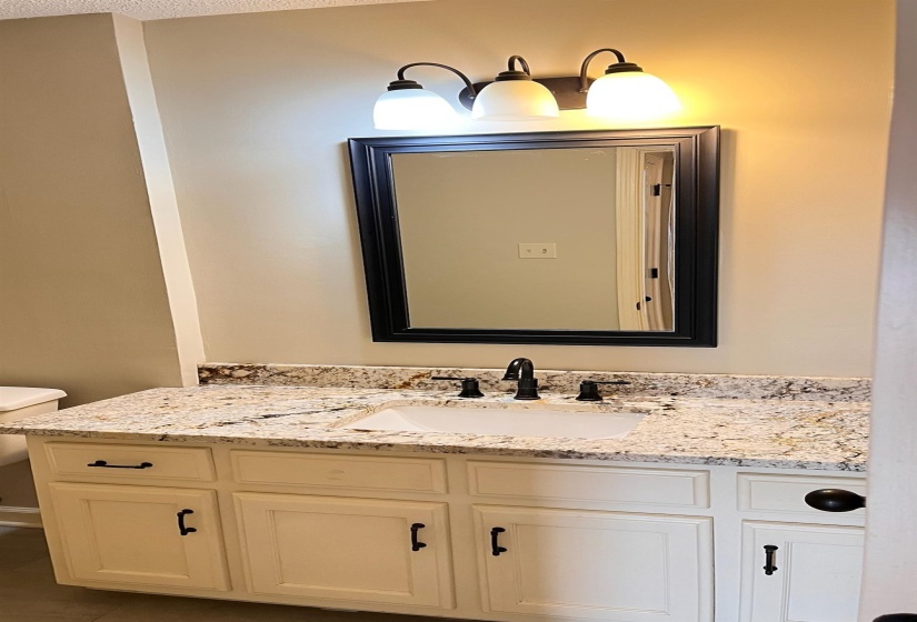 Half bathroom with vanity and dark tile patterned floors