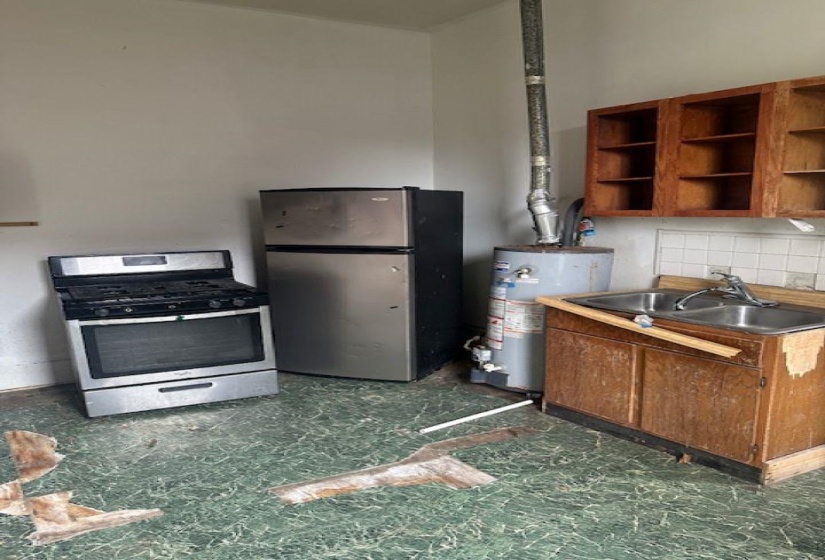 Kitchen area featuring a stainless steel refrigerator and range