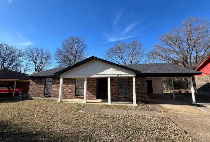 Single story home featuring a porch, a carport, concrete driveway, brick siding, and a front lawn
