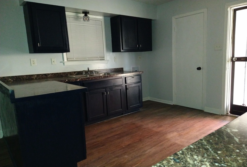 Kitchen featuring dark wood finished floors and dark cabinets