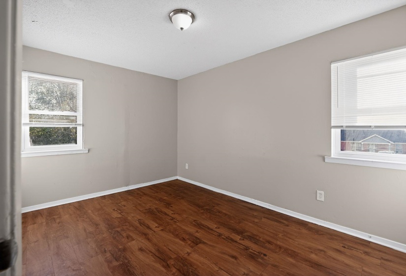 Spare room featuring dark wood finished floors and a textured ceiling