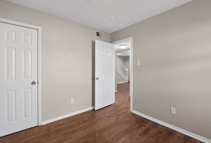 Unfurnished bedroom featuring dark wood-style flooring and a textured ceiling