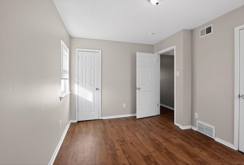 Unfurnished bedroom with dark wood-style floors and a textured ceiling