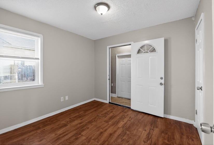 Unfurnished bedroom featuring a textured ceiling and dark wood-style flooring