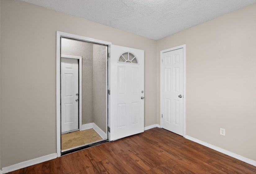 Unfurnished bedroom featuring a textured ceiling and dark wood-style floors