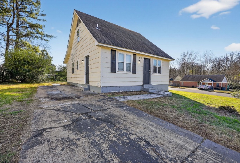 Bungalow-style home with a front yard, roof with shingles, driveway, and entry steps
