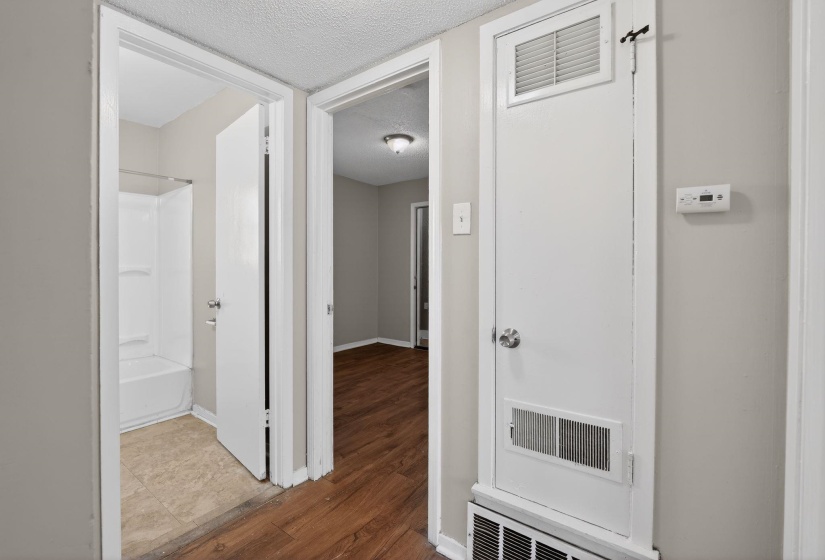 Hall with wood finished floors and a textured ceiling